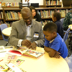 child and mentor reading together